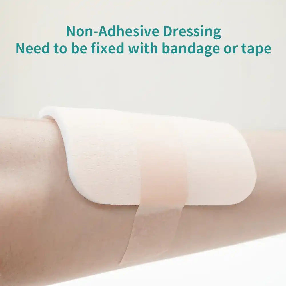 Non-adhesive medical dressing on arm, secured with medical tape, wound care product